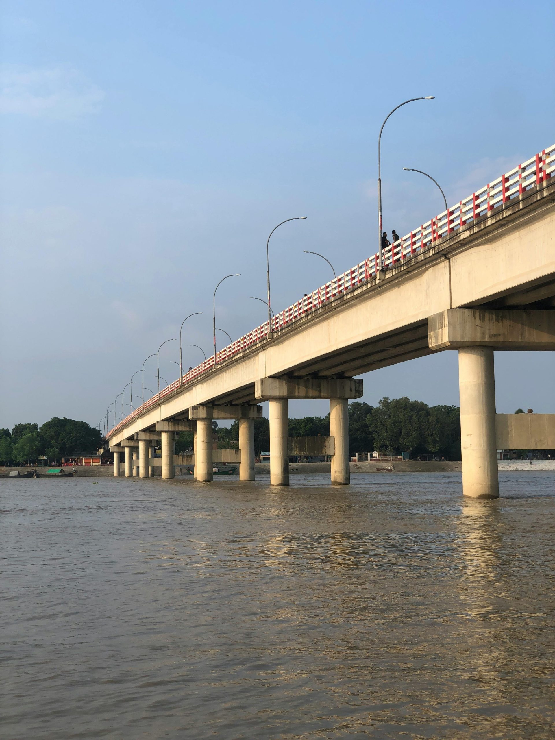 Scenic view of a concrete bridge spanning the Padma River in Kushtia, Bangladesh, with calm waters below.